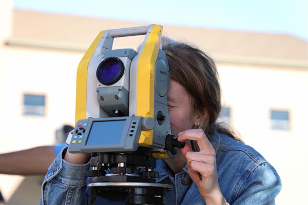 Girl looking using surveying equipment