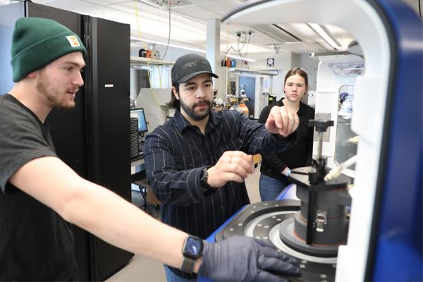 Mechanical engineering students using equipment in a lab